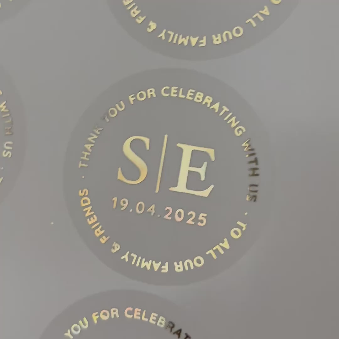 Load video: Personalised initial favour Wedding Stickers with date stating 'thank you for celebrating with us and to all our family & friends, moving to show the high shine gold foil finish