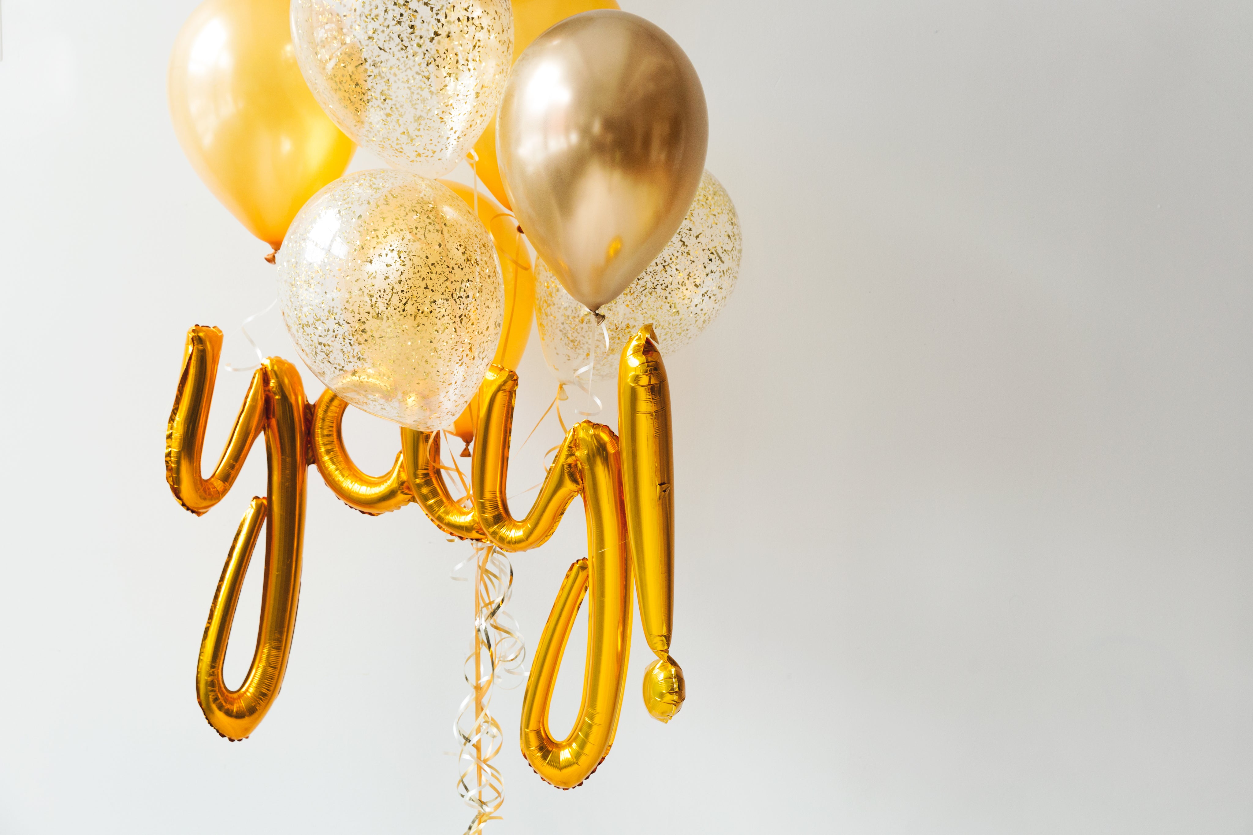 shades of gold and gold confetti balloons and 'y-a-y' balloons clustered together
