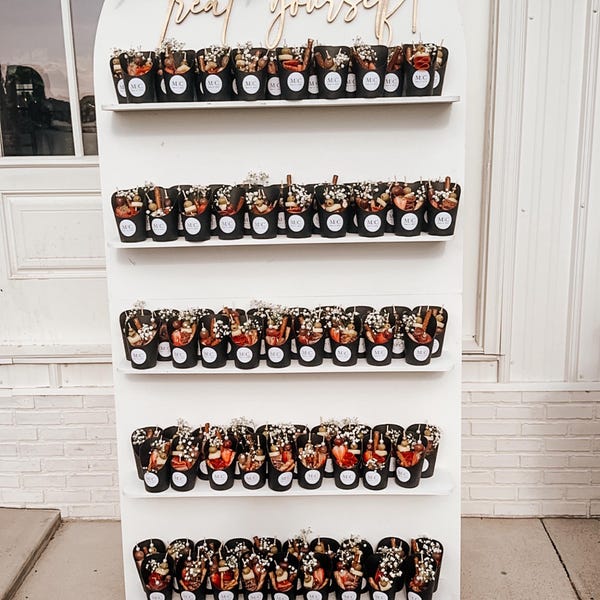 customer photo showing a wall of personalised candy cups with personalised classic initial wedding stickers