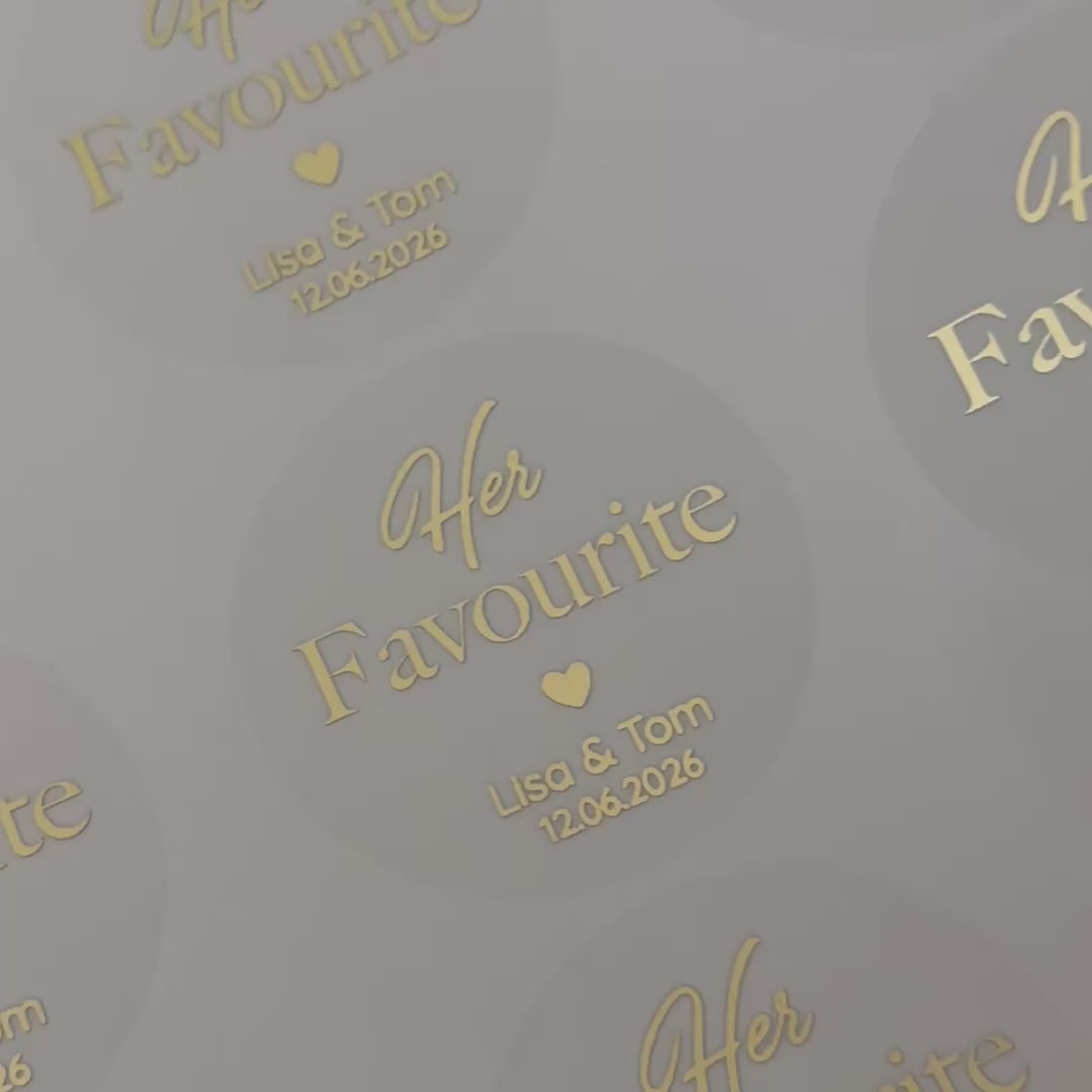 Load video: Personalised &#39;her favourite&#39; Wedding Stickers with names and date moving to show the high shine gold foil finish