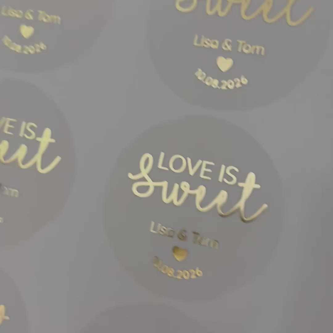 Load video: Personalised &#39;love is sweet&#39; Wedding favour Stickers moving to show the high shine gold foil finish